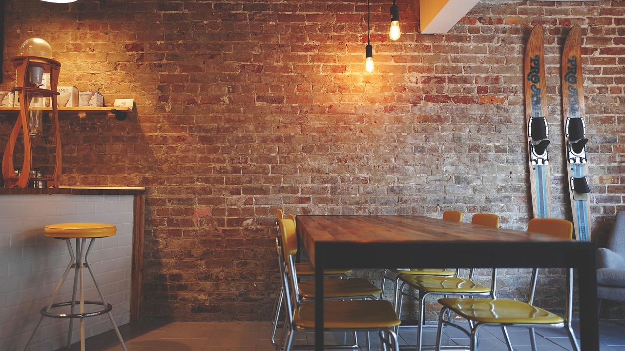 Wohnraum mit Holztisch und Ziegelwand