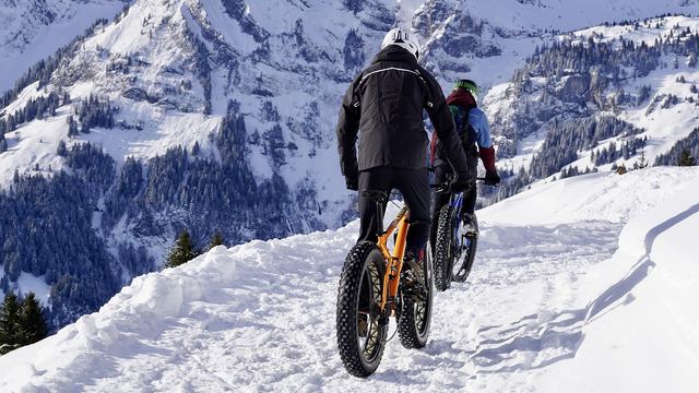 Radfahrer mit breiten Reifen im Schnee, von hinten